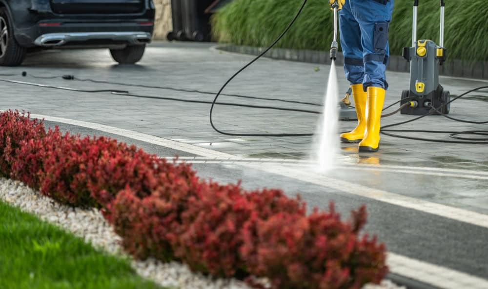A homeowner power washing his driveway.
