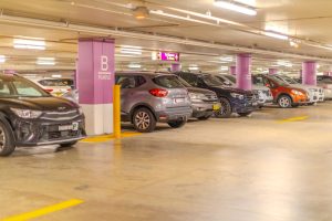 Indoor commercial car park with multiple vehicles parked in marked bays under bright lighting, showing typical CBD parking layout in Australia.