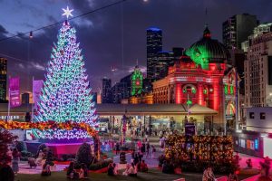 Christmas tree at Federation Square with Flinders Street Station lit up during December in Melbourne