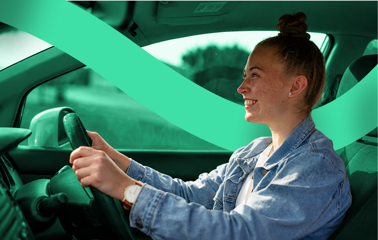 A driver smiling behind the wheel of their car