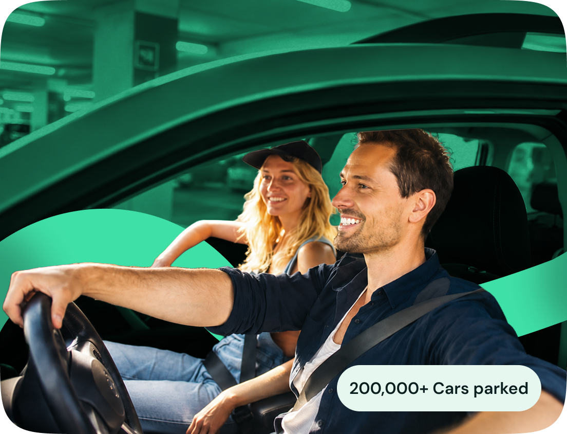 Two people smiling as they drive into a parking spot